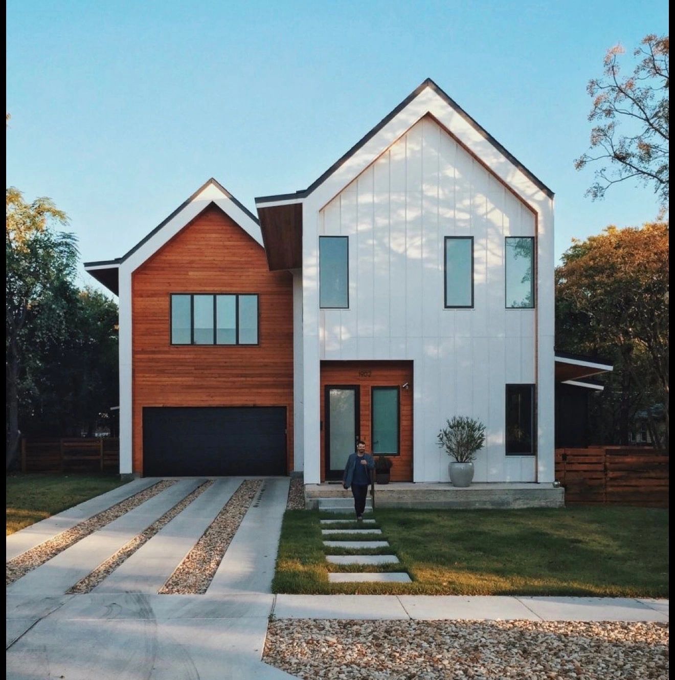 Modern two-story home exterior with wood and white siding