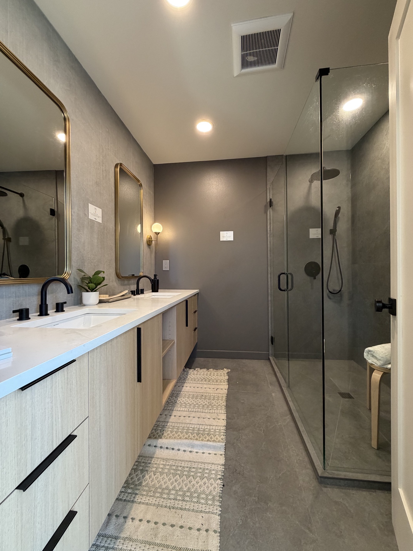 Large bathroom with double vanity, black fixtures and glass walk-in shower