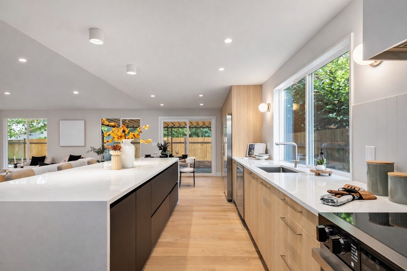 Bright remodeled kitchen with large island, wood cabinets and garden windows